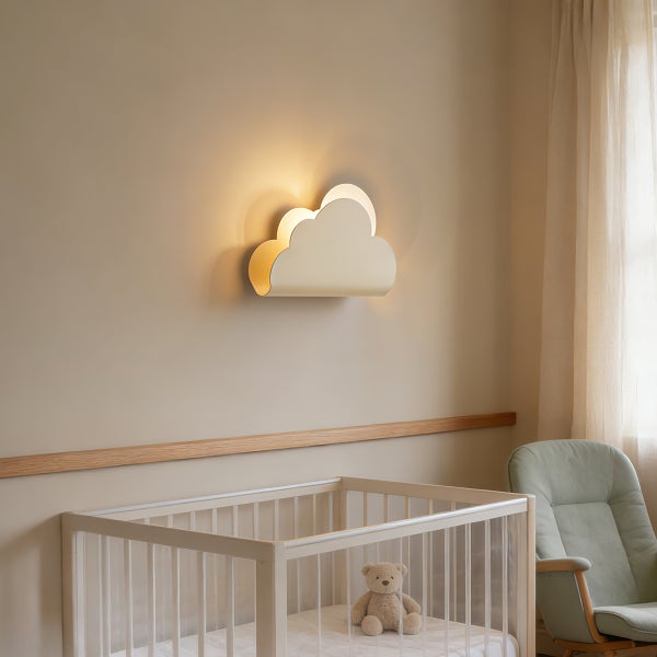 Wolkenförmige Wandleuchte für das Kinderzimmer, montiert an der Wand über einem Gitterbett mit einem Teddybären in einem hellen Zimmer.