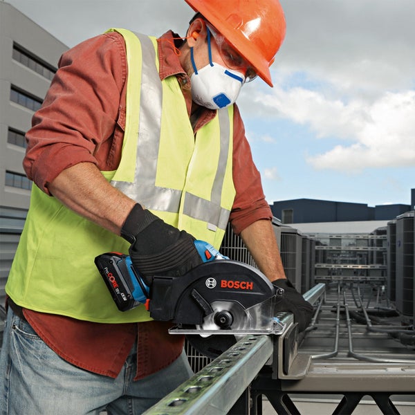 Ein Bauarbeiter sägt mit einer Bosch Akku-Kreissäge ein Metallstück.