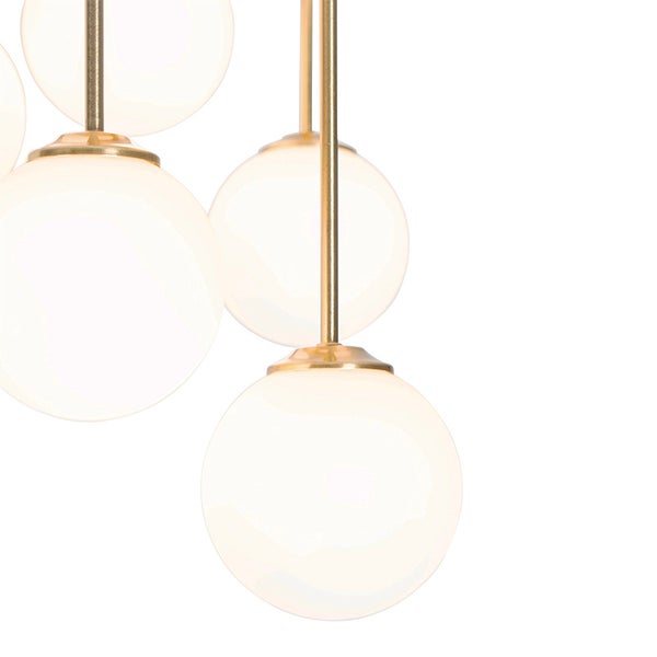 Pendelleuchte mit mehreren runden, weißen Glaslampenschirmen und goldfarbenen Metallaufhängungen.