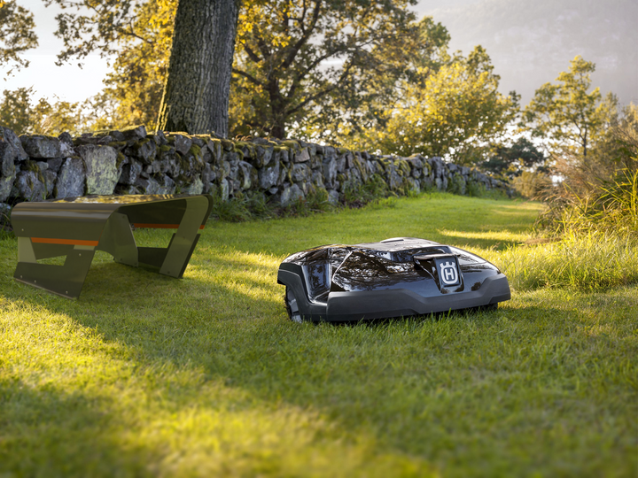 Szene mit Rasenroboter und Rasenbank auf einer Rasenfläche