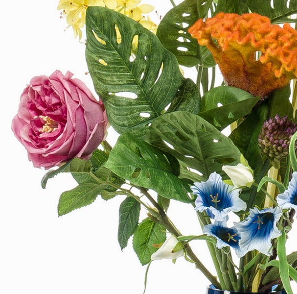 Künstlicher Blumenstrauß mit rosa Rose, grünem Monstera-Blatt sowie blauen, orangefarbenen, gelben und weißen Blüten.