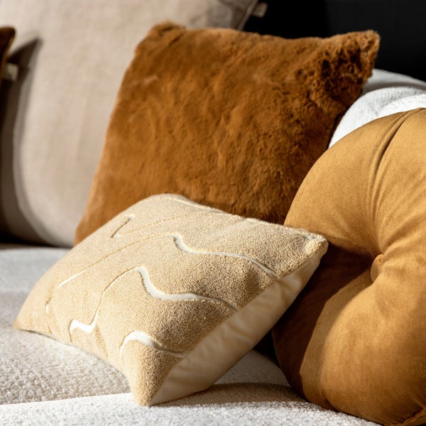 Dekorative Kissen in verschiedenen Formen und Texturen auf einem Sofa