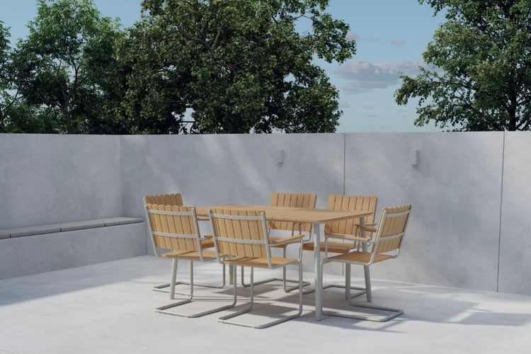 Moderne Garten-Sitzgruppe mit Holztisch und Freischwinger-Stühlen auf einer hellen Betonterrasse vor Bäumen.