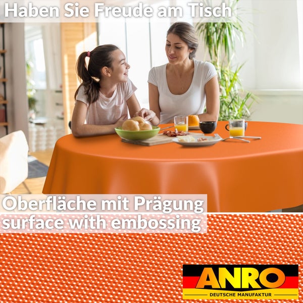 Runde orangefarbene Tischdecke mit geprägter Oberfläche auf einem gedeckten Tisch. Detailansicht der Struktur und ANRO Logo.