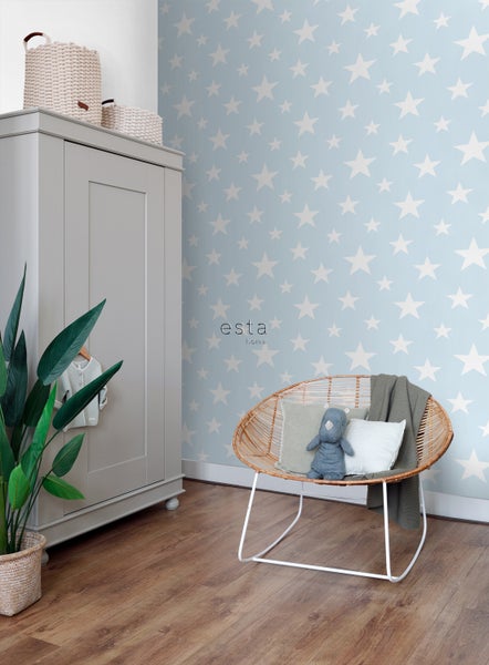 Babyzimmer mit Sternentapete, Korbsessel und Kleiderschrank