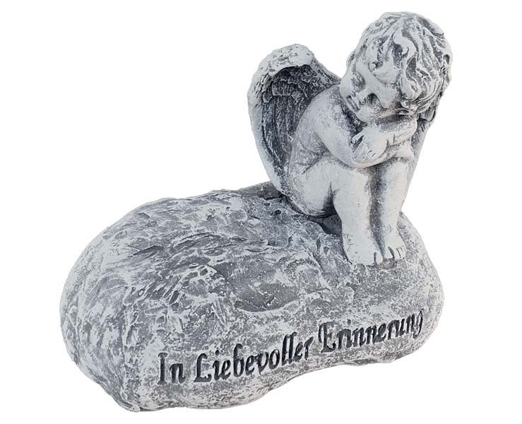 Grabfigur trauernder Engel auf einem Stein mit der Aufschrift In liebevoller Erinnerung als dekoratives Element für den Friedhof