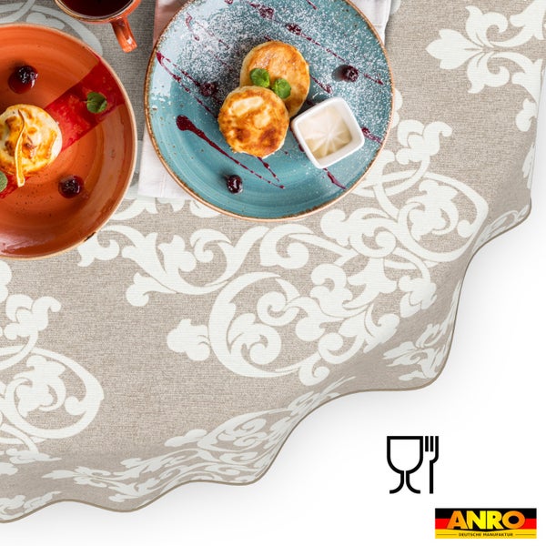 Runde Tischdecke mit barockem Ornamentmuster, gedeckt mit Speisen und Geschirr, lebensmittelecht, ANRO Logo.