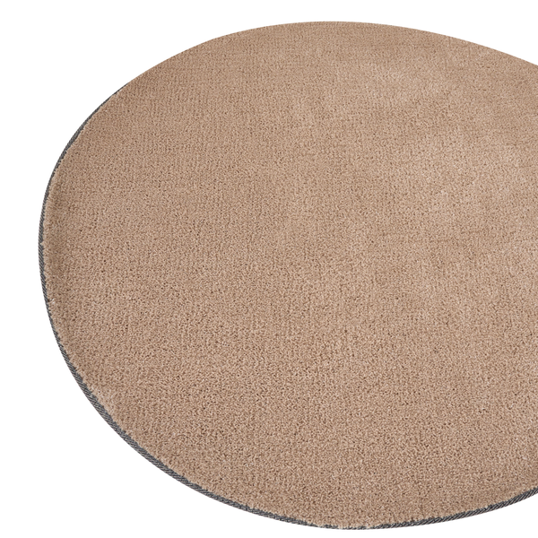 Runder beige Teppich mit strukturierter Oberfläche und geketteltem Rand.