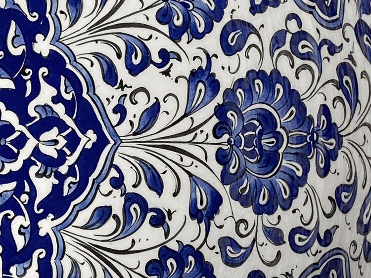 Detailaufnahme eines Musters mit floralen Motiven in Blau auf hellem Grund.