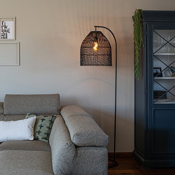 Wohnzimmer mit Sofa, Vitrine und Bogenlampe mit Schirm aus Rattan