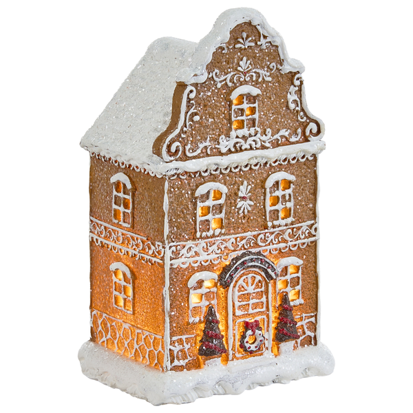 Beleuchtete Lebkuchenhaus Dekoration auf Sideboard neben Tannenbaum und Fenster für weihnachtliche Stimmung