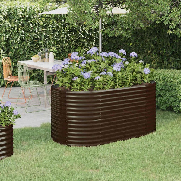 Ovales Hochbeet aus Wellblech in einem Garten mit Hortensien bepflanzt, neben einem Terrassentisch mit Sitzgelegenheiten.