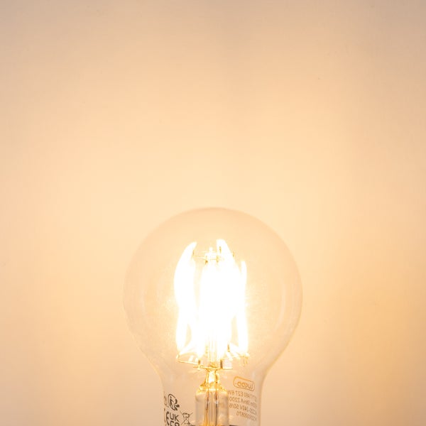 Eingeschaltetes LED-Filament-Leuchtmittel in Birnenform aus Klarglas mit warmweißem Licht.
