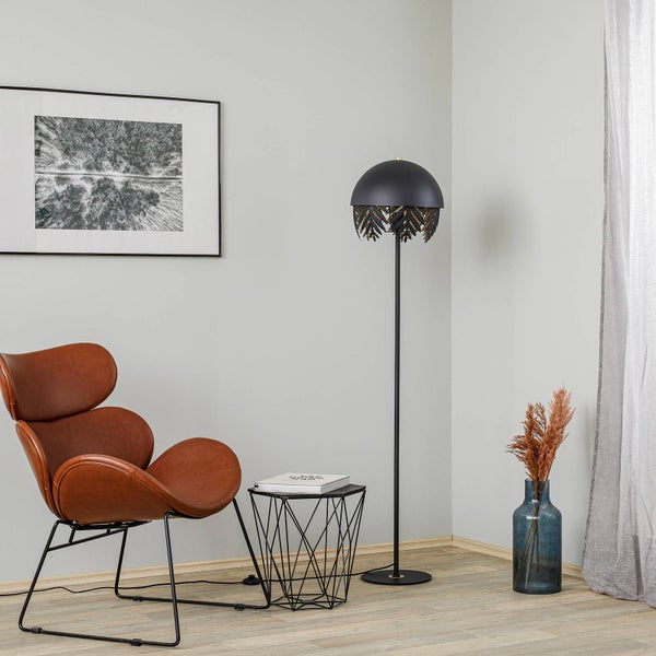 Wohnzimmer-Szene mit Sessel, Stehlampe, Beistelltisch, Dekoration und Bilderrahmen