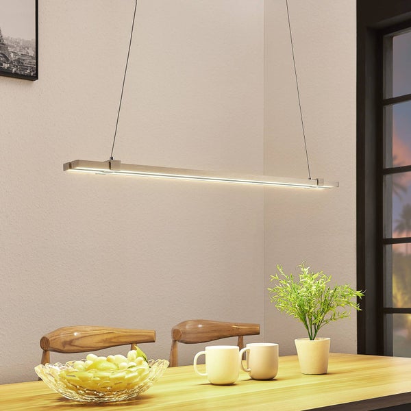 Moderne lineare LED-Pendelleuchte aus Holz über einem Holztisch in einem hellen, organisierten Esszimmer mit Stühlen und Dekoration.