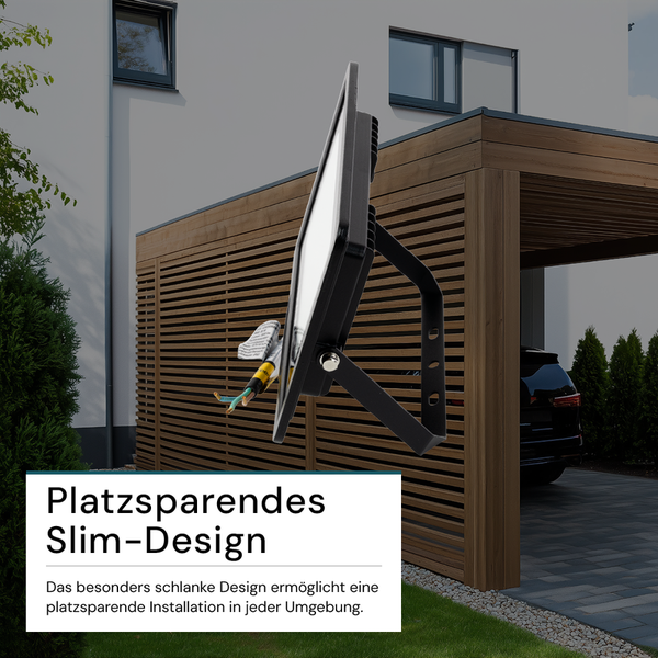 Schwarzer LED-Strahler vor einem modernen Haus mit Carport