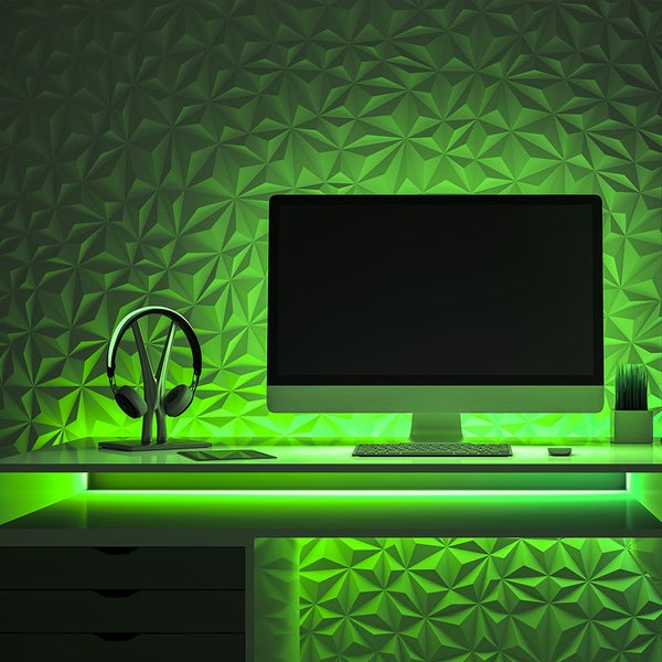 Arbeitszimmer mit Schreibtisch, Monitor, Kopfhörer und dreidimensionalen Wandpaneelen