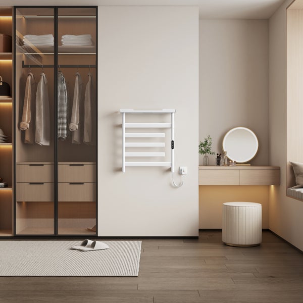 Elektrischer Handtuchheizkörper in einem modernen Ankleidezimmer mit Kleiderschrank, Schminktisch und Parkettboden.