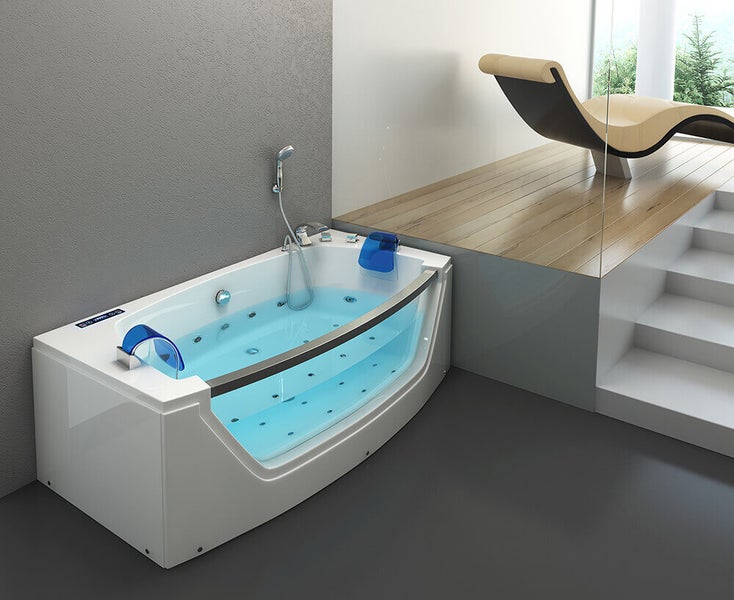 Moderne Whirlpool Badewanne mit Glasfront und Duschkopf in einem geräumigen Badezimmer mit Holzpodest und Liegestuhl.