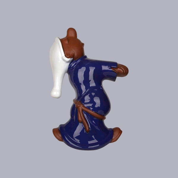 Dekorationsfigur Bär in blauem Nachtgewand mit weißer Schlafmütze, glänzende Oberfläche.
