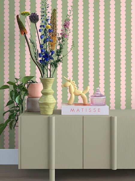 Vliestapete mit vertikalem Punktmuster hinter einem Sideboard mit Blumen und Dekoration
