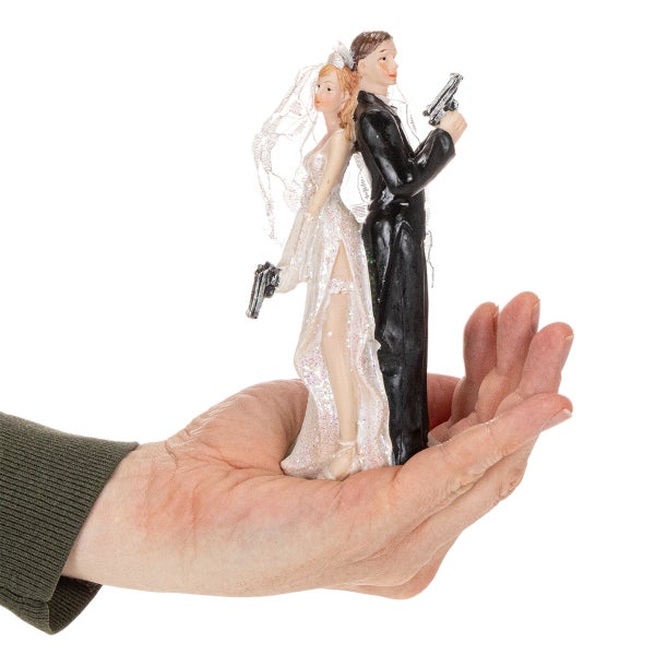 Tortenfigur Brautpaar mit Pistolen, Rücken an Rücken stehend auf einer Hand.