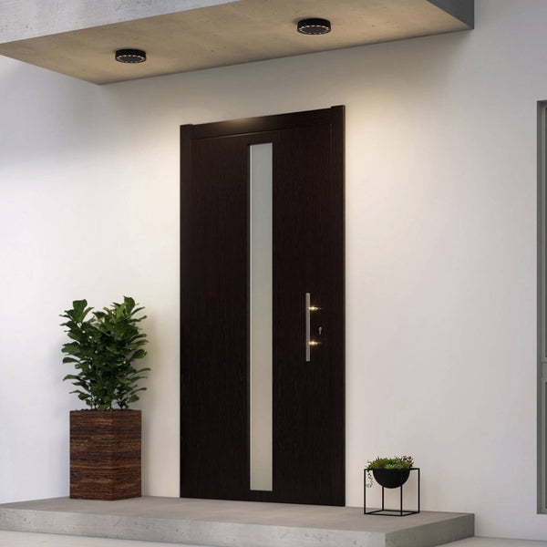 Moderne Haustür in dunklem Braun mit vertikalem Lichtausschnitt aus Glas und silbernem Griff in einem hellen Eingangsbereich.