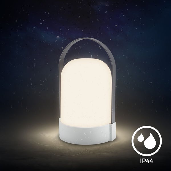Tragbare LED-Außenleuchte mit Tragebügel und IP44 Spritzwasserschutz, leuchtend bei Nacht im Garten.