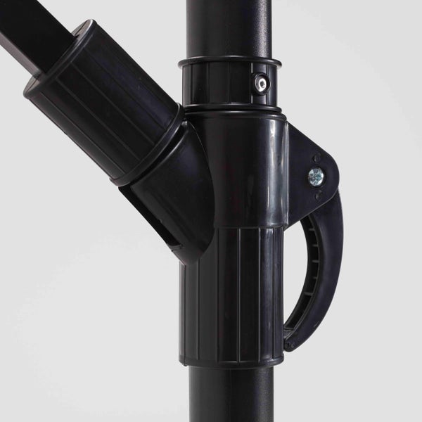 Nahaufnahme des schwarzen Kunststoff-Schiebemechanismus und Griffs an einem Sonnenschirmmast zur Höhen- oder Neigungsverstellung.