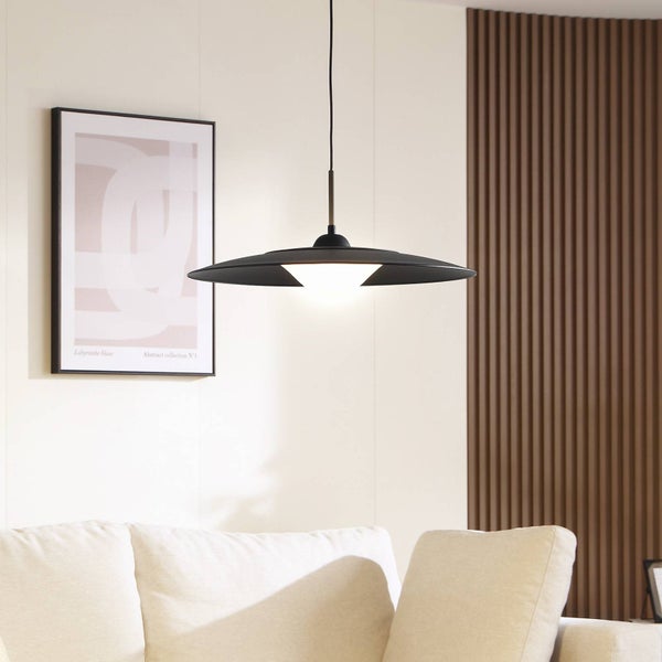 Schwarze Pendelleuchte in Scheibenform über hellem Sofa, modernes Wohnzimmer mit Holzlamellenwand und abstraktem Bild.