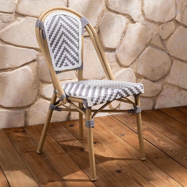 Bistrostuhl mit Gestell in Rattan-Optik und grau-weißem Geflecht im Zickzack-Muster auf Sitz und Rückenlehne auf einer Holzterrasse.