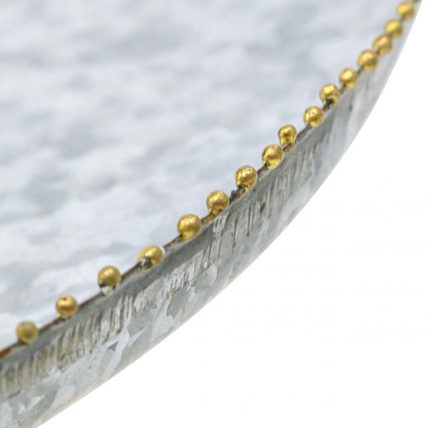 Detailansicht eines runden Dekorationstabletts aus Metall mit goldenen Zierkugeln am Rand.