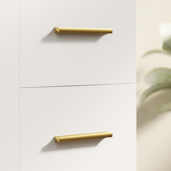 Zwei schmale, goldfarbene Möbelgriffe an weißen Schubladen in modernem Design.