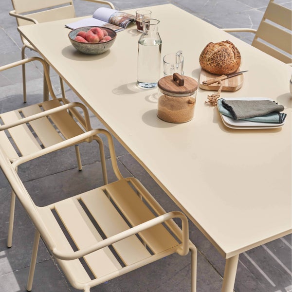 Modernes Gartenmöbel-Set aus Metall mit einem großen Esstisch und passenden Stühlen mit Lamellen auf einer Steinterrasse.
