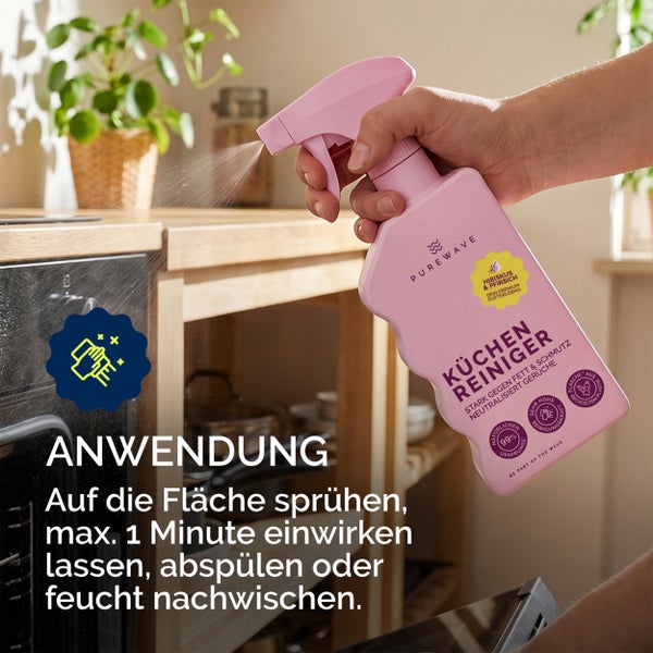 Eine Hand sprüht Purewave Küchenreiniger mit Hibiskus und Pfirsich Duft auf einen Backofen. Anwendungshinweise sind auf dem Bild enthalten.