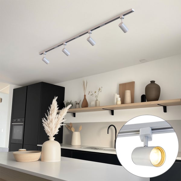 Moderne Deckenstromschiene mit vier verstellbaren LED Strahlern in einer hellen Küche mit schwarzen Küchenschränken und Holzregalen.