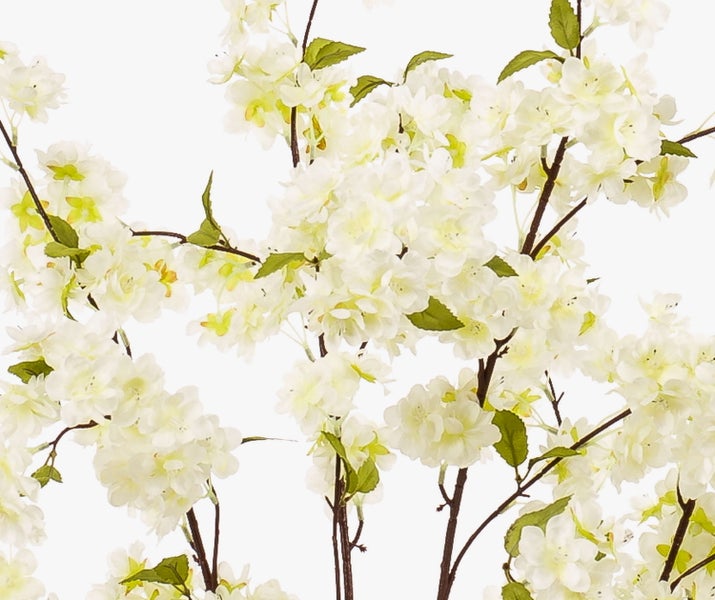 Künstlicher Blütenzweig mit weißen Kirschblüten und kleinen grünen Blättern.
