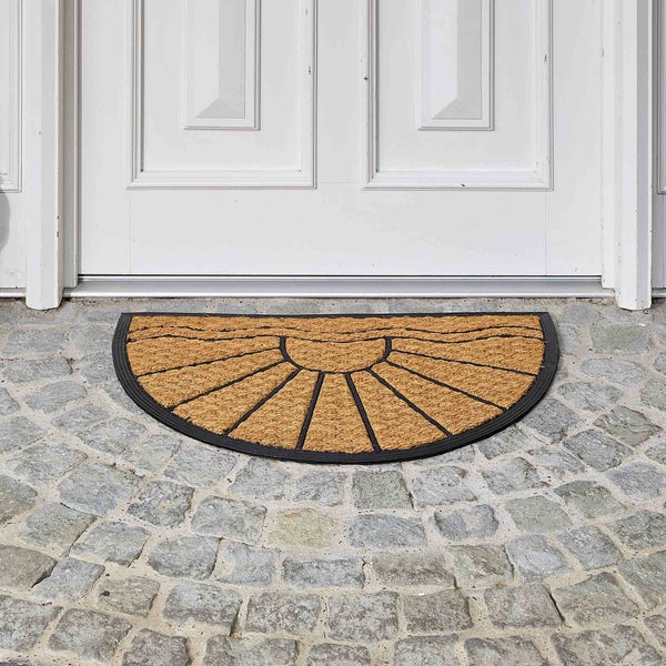 Halbrunde Fußmatte aus Kokosfaser mit Sonnenmuster vor einer Haustür.