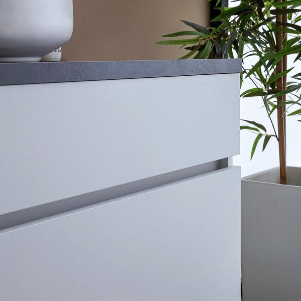 Detailaufnahme eines Badezimmerschranks mit Schubladen und einer Pflanze