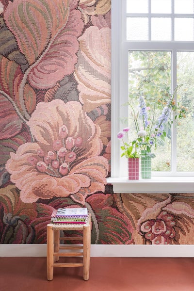 Raum mit floraler Tapete, Fenster und kleinem Holzhocker mit Zeitschriften