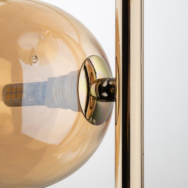 Detailaufnahme einer goldenen Kugel-Lampe mit LED-Leuchtmittel.