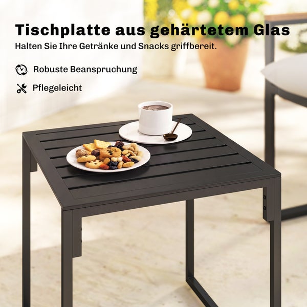 Schwarzer Garten-Beistelltisch mit Glasplatte aus gehärtetem Glas, darauf eine Tasse Kaffee und ein Teller mit Keksen.