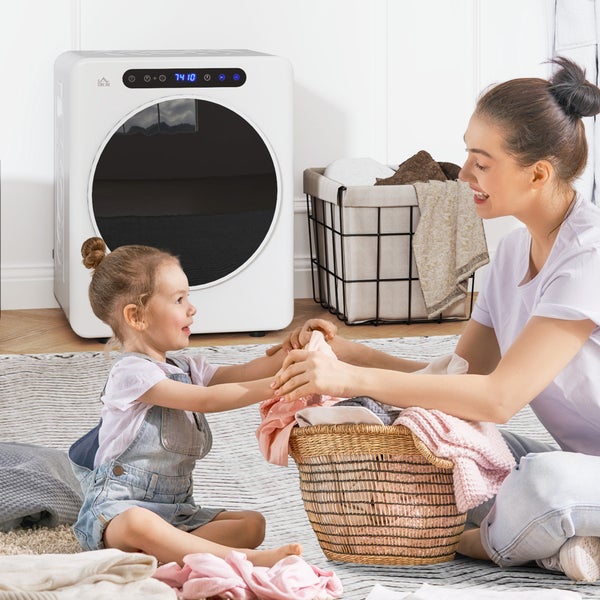 Kompakter weißer Wäschetrockner mit runder schwarzer Tür in hellem Raum, in dem eine Frau und ein Kind Wäsche in einen Korb legen.