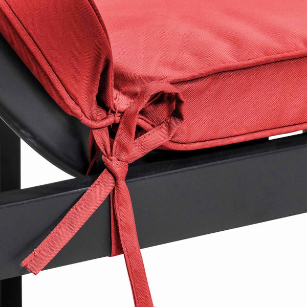 Rotes Sitzkissen für Gartenmöbel mit Befestigungsband an einem schwarzen Rahmen.