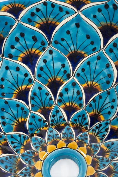 Detailansicht einer Keramikfliese mit blauem, floralem Muster