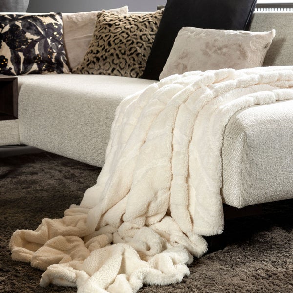 Beige Sofadecke auf einem Sofa mit Kissen