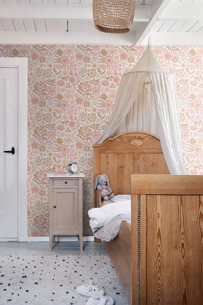 Einrichtungsszene mit floraler Mustertapete, einfarbig gestrichener Wand mit Zierleiste und einem Kleiderschrank aus Holz.