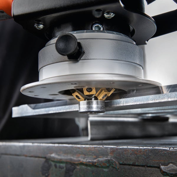 Kantenfräsmaschine bei der Bearbeitung einer Metallplatte mit einem Fräskopf und Wendeschneidplatten zur Erzeugung einer Fase.