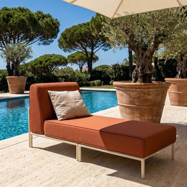 Moderne Gartenliege mit terrakottafarbenen Polstern und weißem Metallgestell auf einer Terrasse am Pool mit Olivenbäumen in Töpfen.