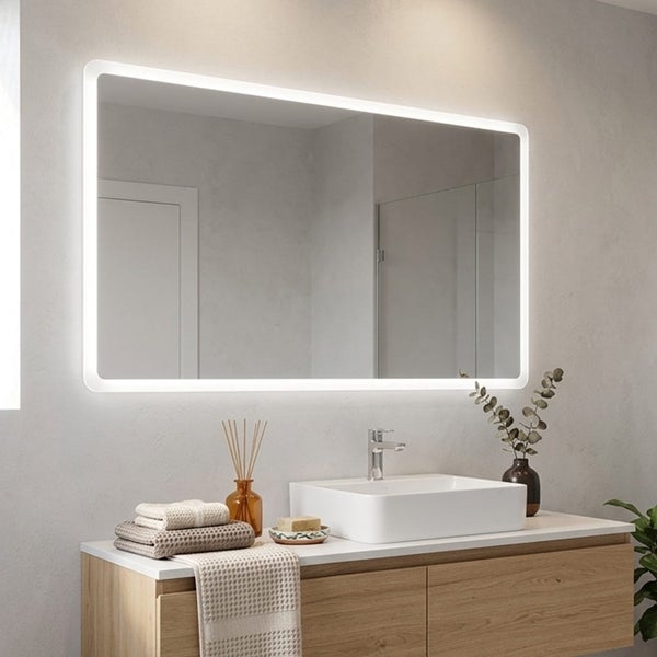 Rechteckiger LED-Badezimmerspiegel mit abgerundeten Ecken und umlaufender Beleuchtung in einem hellen, modernen Badezimmer über einem Aufsatzbecken.